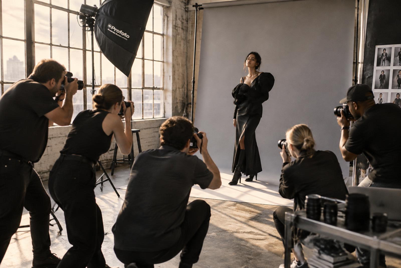 Photographers shooting a model together in a sunlit loft studio